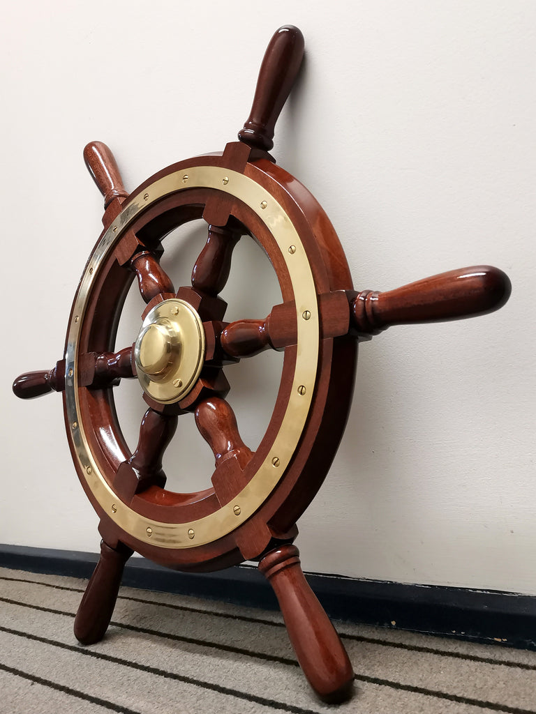 Mahogany steering wheel leaning against wall on angle